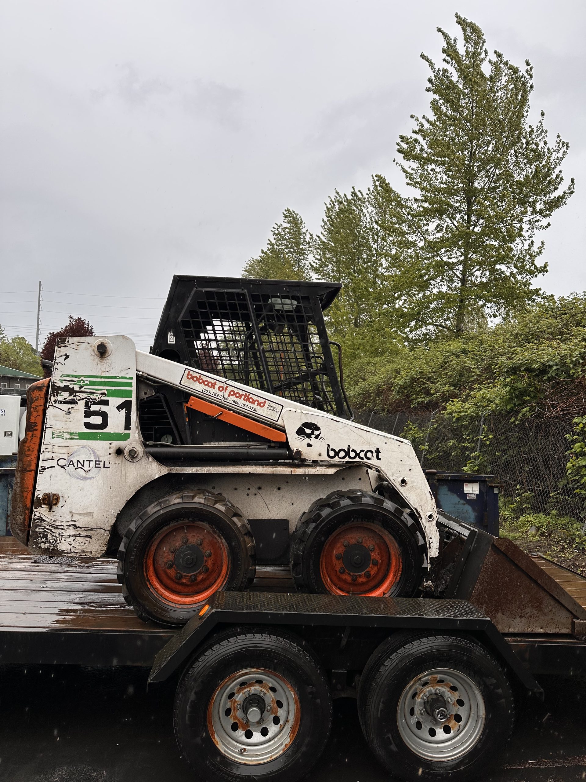 Profile view of 1998 Bobcat 751 skidsteer, placed on a flatbed trailer.